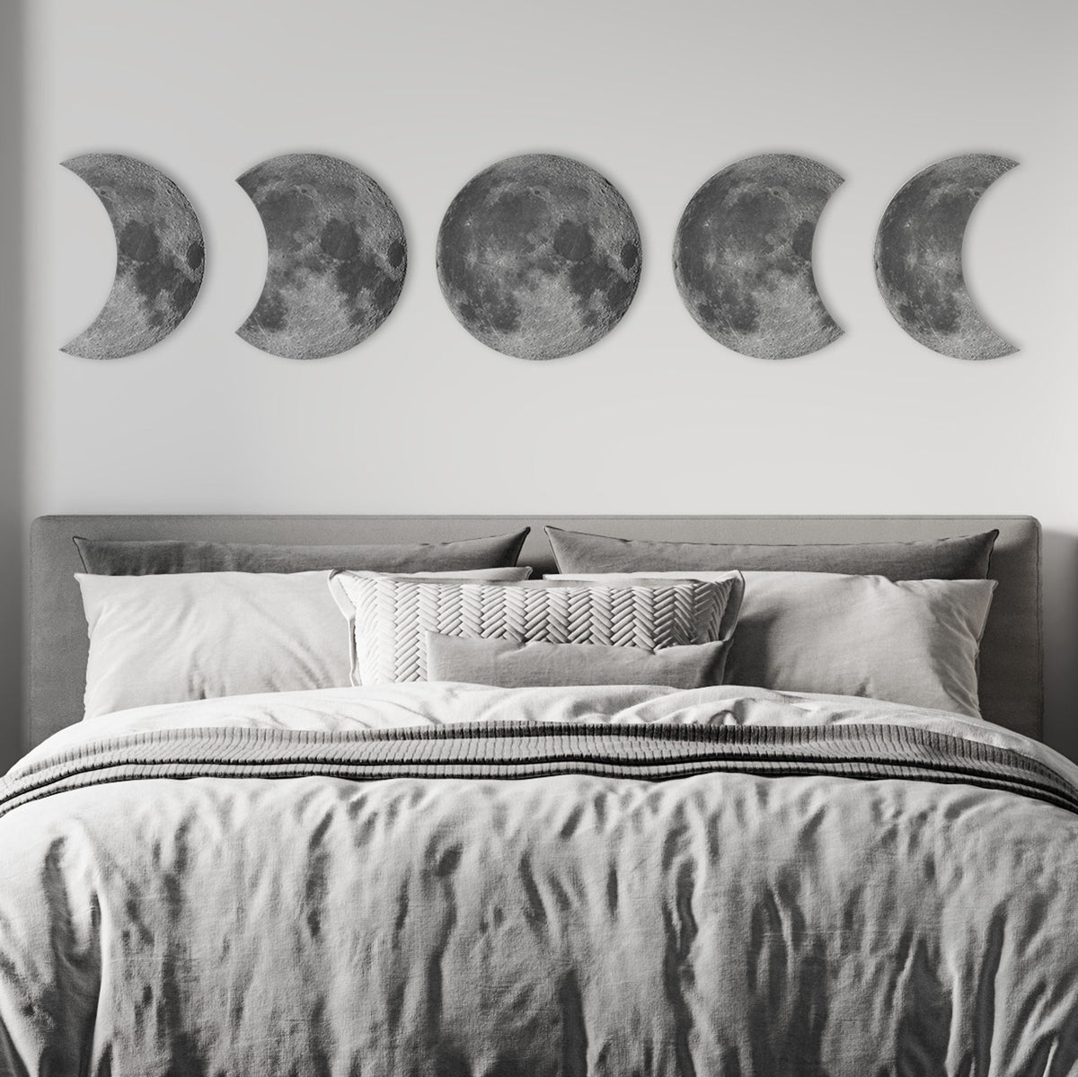 Moon phases wall decor displayed above bed in modern bedroom, celestial wall art focal point