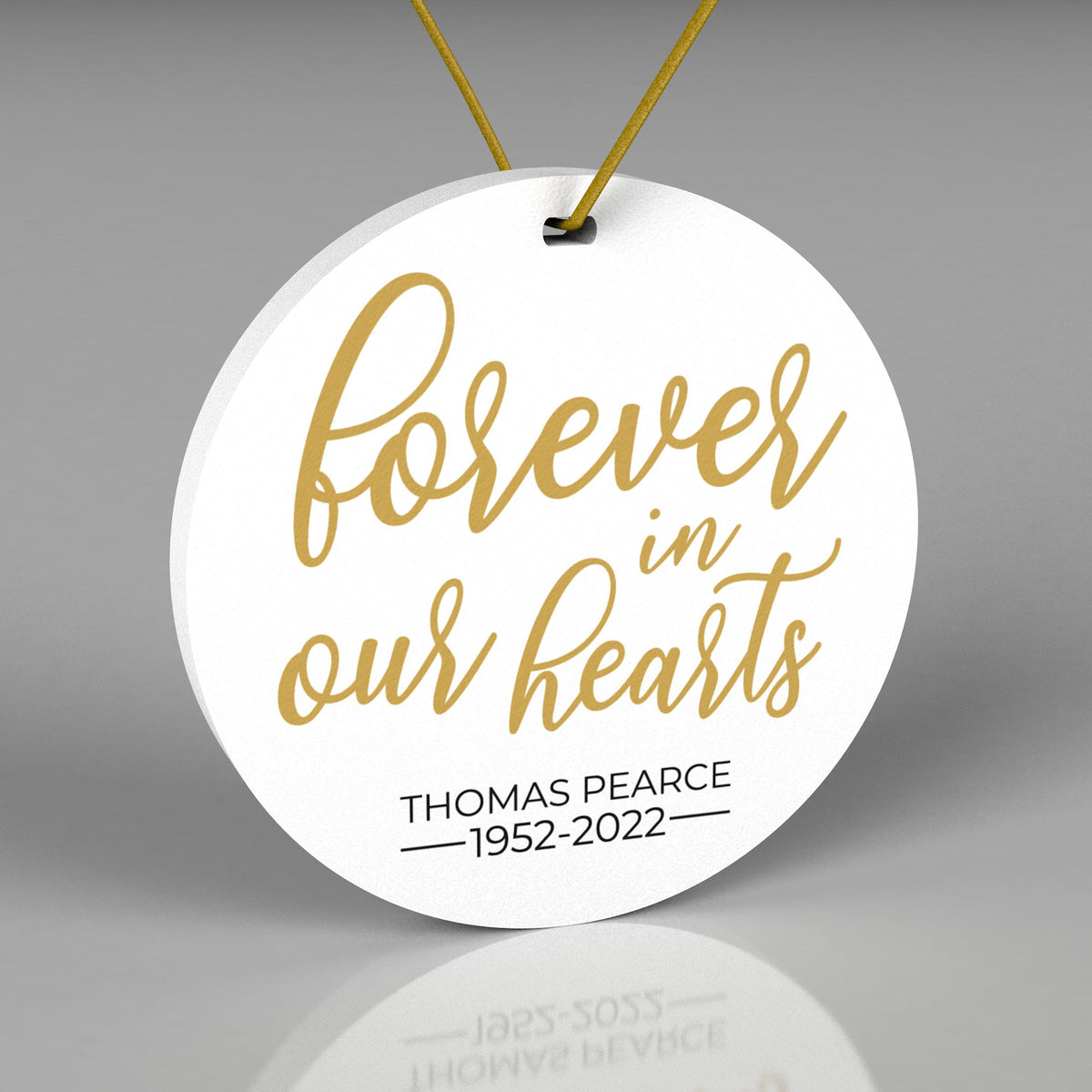 Round Christmas ornament saying Forever in Our Hearts with Name and Birth/Date date.  White Background with Gold and Black writing