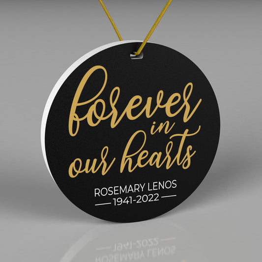 Round Christmas Ornament with black background. Saying Forever in Our Hearts in Gold text.  Name and birth/death year at the bottom in white text