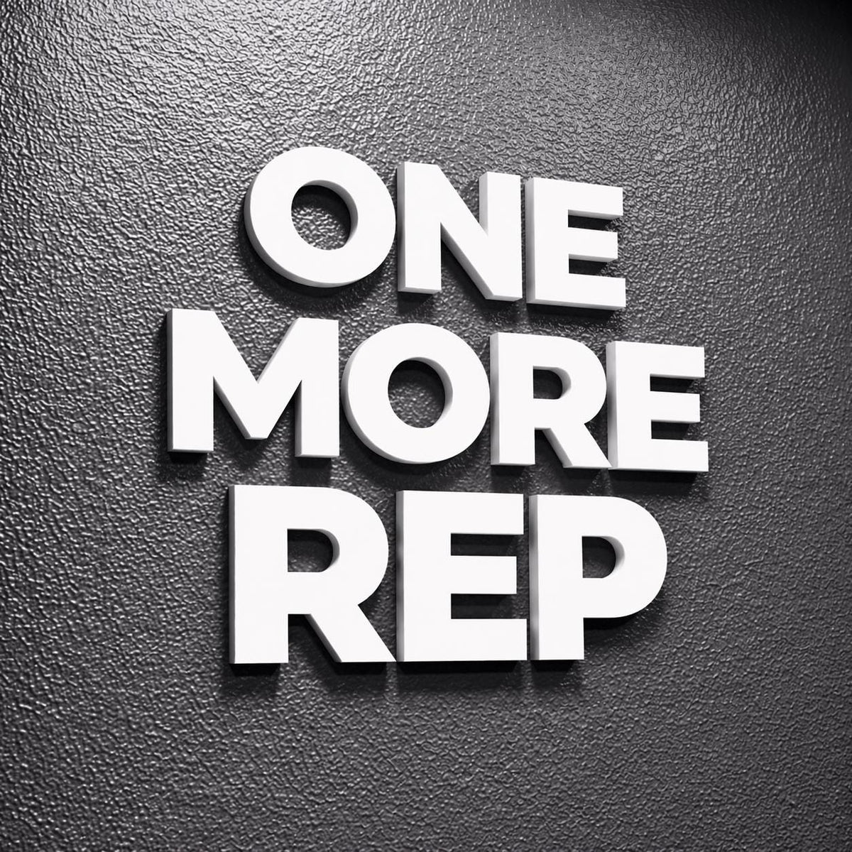 White 3D text on a textured dark gray background reads "ONE MORE REP." The letters are bold and stand out, creating a motivational message. The image is a close-up, emphasizing the text's prominence.