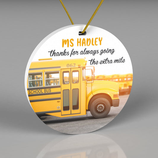 Round Christmas ornament with a realistic yellow school bus. Wording says "thanks for always going the extra mile"